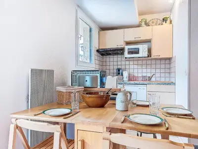 a wooden table with plates on it in a room with windows at Apartment La Comtesse-9 by Interhome in Saint-Gervais-les-Bains