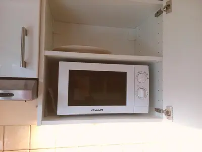 a microwave oven in a kitchen with a cabinet at Studio Les Drus / Studio du Brévent in Chamonix-Mont-Blanc