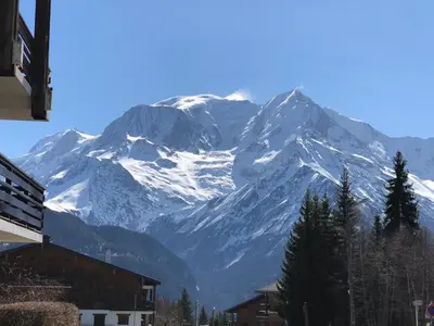 a snow covered mountain in the background of a city at L'Ècrin Alpin in Saint-Gervais-les-Bains