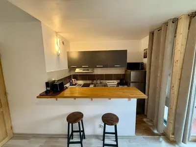 a kitchen with a counter and two stools at L'Ècrin Alpin in Saint-Gervais-les-Bains