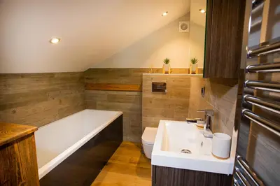 a bathroom with a tub and a toilet and a sink at Chalet Byram in Saint-Gervais-les-Bains
