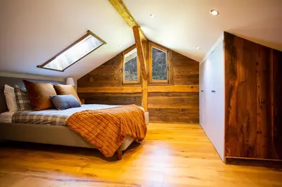 a bedroom with a bed in a room with wooden walls at Chalet Byram in Saint-Gervais-les-Bains