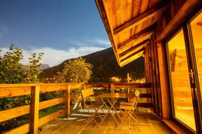 a wooden balcony with a table and chairs on it at Chalet Byram in Saint-Gervais-les-Bains