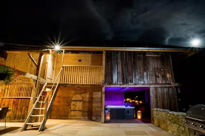 a wooden building with a ladder in front of it at night at Chalet Byram in Saint-Gervais-les-Bains