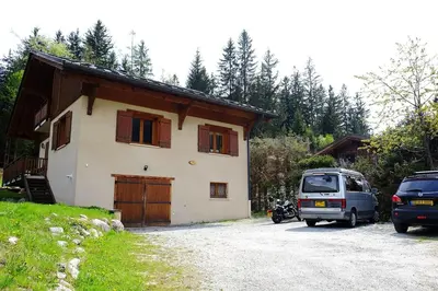 a house with a car parked in front of it at Chamonix Large Chalet, Sleeps 12, 200m2, 5 Bedroom, 4 Bathroom, Garden, Jacuzzi, Sauna in Chamonix-Mont-Blanc
