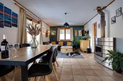 a dining room and living room with a table and chairs at Chamonix Large Chalet, Sleeps 12, 200m2, 5 Bedroom, 4 Bathroom, Garden, Jacuzzi, Sauna in Chamonix-Mont-Blanc