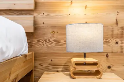 a lamp on a wooden table in a bedroom at Apt. Grand Paradis B14 - Modern with Mont Blanc view in Chamonix-Mont-Blanc