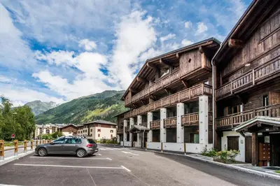 a car parked in a parking lot in front of a building at Apt. Grand Paradis B14 - Modern with Mont Blanc view in Chamonix-Mont-Blanc