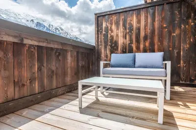 a bench on a deck with mountains in the background at Apt. Grand Paradis B14 - Modern with Mont Blanc view in Chamonix-Mont-Blanc