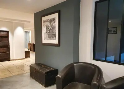a living room with a leather chair and a ottoman at Chalet Hôtel du Bois in Les Houches