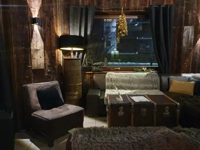 a living room with a chair a couch and a window at Chalet Hôtel du Bois in Les Houches