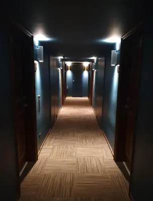 a dark hallway with a long aisle with lights at Chalet Hôtel du Bois in Les Houches