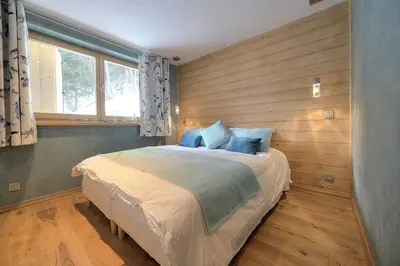 a bedroom with a large bed with a wooden wall at 