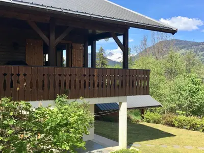 a wooden pavilion with a bench in a garden at Chalet du Meilly in Saint-Gervais-les-Bains