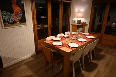 a dining room table with white plates and chairs at Chalet du Meilly in Saint-Gervais-les-Bains