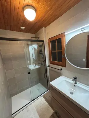 a bathroom with a shower and a sink and a mirror at Chalet du Meilly in Saint-Gervais-les-Bains