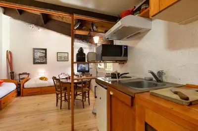 a kitchen with a sink and a table in a room at Résidence Grand Roc - Bruyères 441 - Happy Rentals in Chamonix-Mont-Blanc