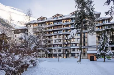 an apartment building in a park with trees at Résidence Pierre & Vacances Le Chamois Blanc in Chamonix-Mont-Blanc