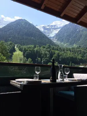 a table with two glasses and a bottle of wine at Appartement face au Mont Blanc & Glaciers in Chamonix-Mont-Blanc
