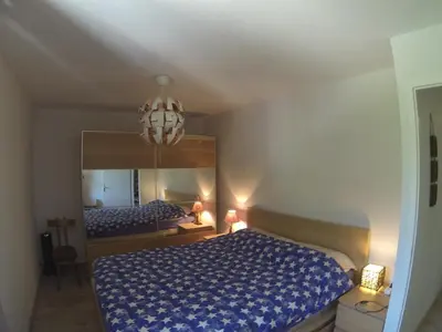 a bedroom with a bed and a large mirror at Appartement face au Mont Blanc & Glaciers in Chamonix-Mont-Blanc