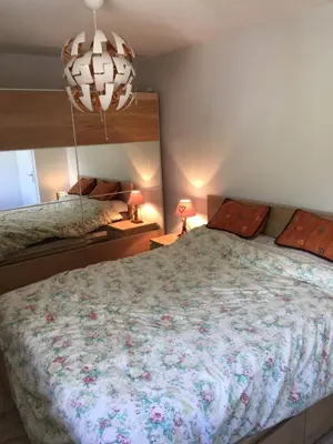 a bedroom with a large bed and a chandelier at Appartement face au Mont Blanc & Glaciers in Chamonix-Mont-Blanc
