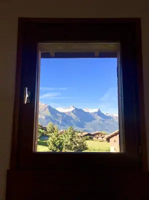 a window in a room with a view of mountains at Appartement cosy et chaleureux à Megève avec vue sur le Mont Blanc in Demi-Quartier