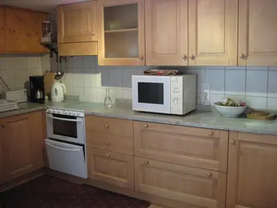 a kitchen with wooden cabinets and a white microwave at Chalets Pyrene Mont-Blanc in Chamonix-Mont-Blanc