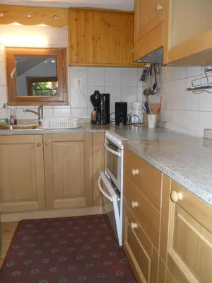 a kitchen with wooden cabinets and a stove top oven at Chalets Pyrene Mont-Blanc in Chamonix-Mont-Blanc