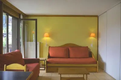 a living room with a couch and a table at Appt 4 /5 pers - 3 min. centre ville in Chamonix-Mont-Blanc