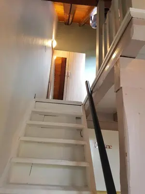 a stairway leading up to the top floor of a house at Studio Duplex Place de la Grenette in Sallanches