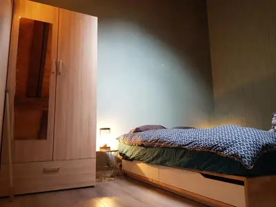 a bedroom with a bed next to a closet at Studio Duplex Place de la Grenette in Sallanches