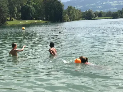 a group of three people swimming in a lake at Studio Duplex Place de la Grenette in Sallanches