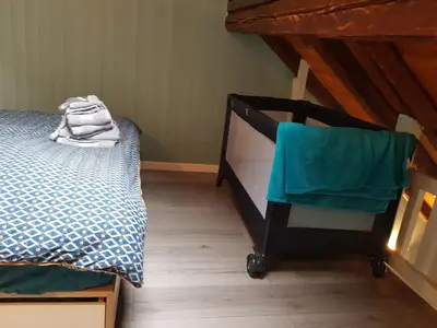 a bedroom with a bed and a chair next to it at Studio Duplex Place de la Grenette in Sallanches