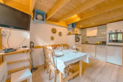 a dining room with a table and a kitchen at Résidence Grand Roc - Campanules 322 - Happy Rentals in Chamonix-Mont-Blanc