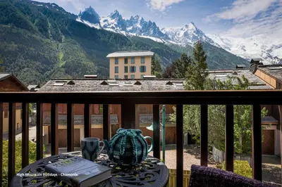 a table on a balcony with a view of mountains at Apartment Chloe in Chamonix-Mont-Blanc