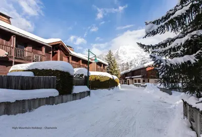 a snow covered street in front of a lodge at Apartment Chloe in Chamonix-Mont-Blanc