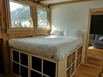 a bed in a room with a window at Beautiful apartment in Chamonix centre with superb mountain views in Chamonix-Mont-Blanc