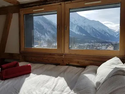 a bedroom with a bed and a window with mountains at Beautiful apartment in Chamonix centre with superb mountain views in Chamonix-Mont-Blanc