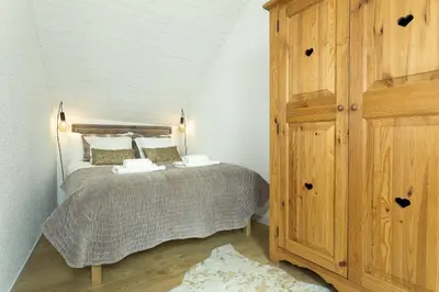 a bedroom with a bed and a wooden cabinet at Apartment Midi Loft - A Central Chamonix Mountain Haven in Chamonix-Mont-Blanc