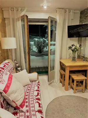 a living room with a couch and a table at les Cimes d'Or Mont blanc in Les Contamines-Montjoie