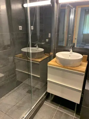 a bathroom with two sinks and a glass shower at les Cimes d'Or Mont blanc in Les Contamines-Montjoie