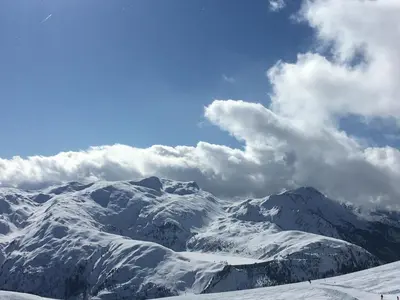 a snow covered mountain range with clouds in the sky at les Cimes d'Or Mont blanc in Les Contamines-Montjoie