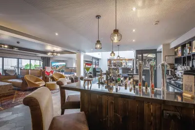 a bar in a restaurant with a bar counter at Chalet Hôtel Le Prieuré & Spa in Chamonix-Mont-Blanc