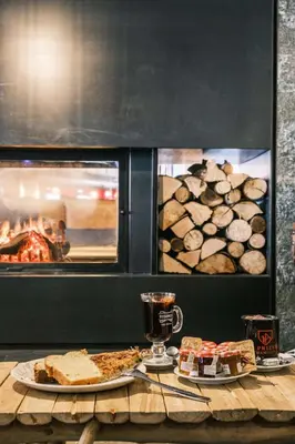 a table with two plates of food and an oven at Chalet Hôtel Le Prieuré & Spa in Chamonix-Mont-Blanc