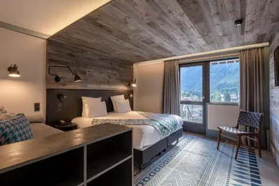 a hotel room with two beds and a window at Chalet Hôtel Le Prieuré & Spa in Chamonix-Mont-Blanc