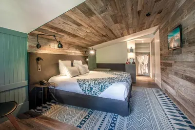 a bedroom with a bed and a wooden ceiling at Chalet Hôtel Le Prieuré & Spa in Chamonix-Mont-Blanc
