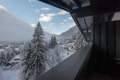 a view from a balcony of a snow covered mountain at Chalet Hôtel Le Prieuré & Spa in Chamonix-Mont-Blanc