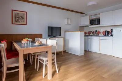 a kitchen and dining room with a table and chairs at Résidence Pierre & Vacances La Rivière in Chamonix-Mont-Blanc