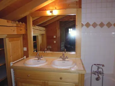a bedroom with a bed with pillows and a lamp at Chambres et Mazots du Chalet de Mado in Megève