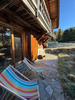 a bedroom with a bed and two tables and chairs at Chambres et Mazots du Chalet de Mado in Megève